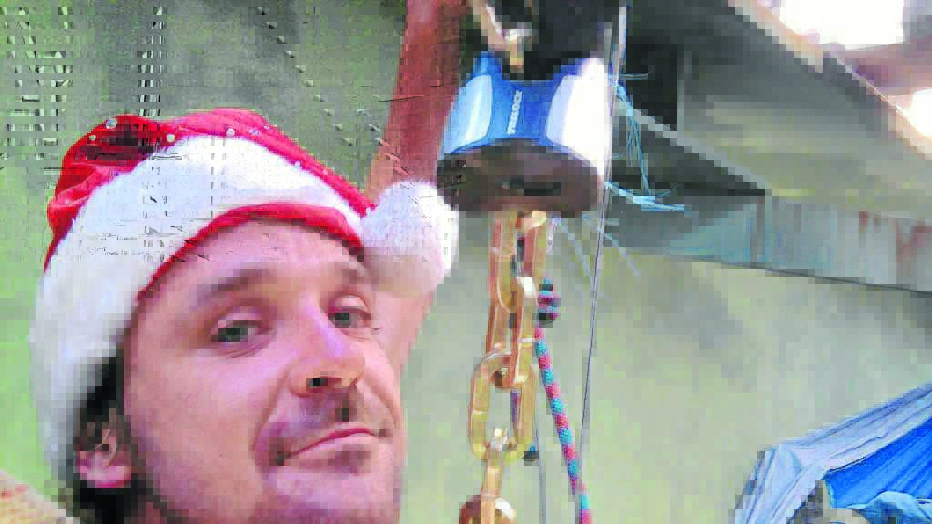 HANGING AROUND: Anti-mining protester Ben Solity shows some Christmas 
spirit despite spending 13 hours suspended from a rail bridge on 
Wednesday.