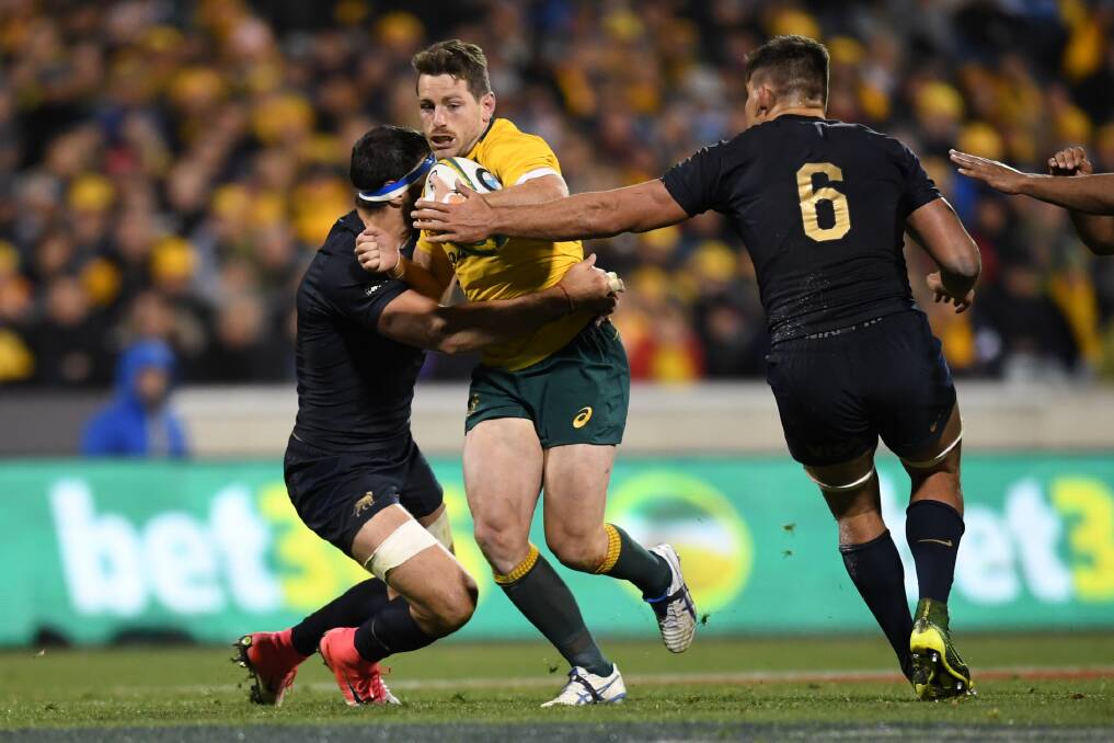 Bernard Foley of the Wallabies (centre) is tackled by Pablo Matera of Argentina (right). Picture: AAP 