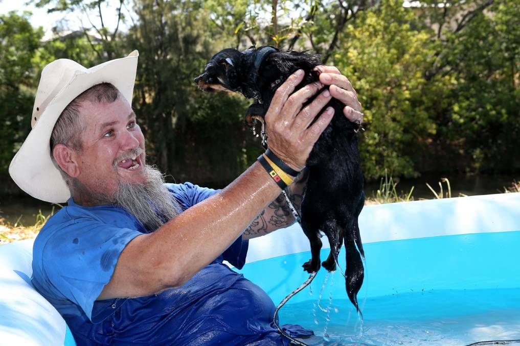 COOLING OFF: Past festival camper Benno Hughes and his pooch Riggy kept cool with a pool. Photo: Matt Bedford 210114MBE01