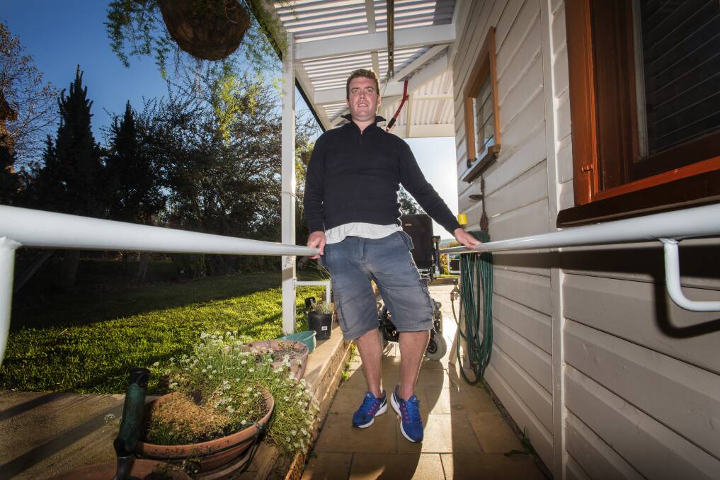 FRUSTRATED: Drew Schofield of Nundle can walk for two metres with the support of these bars but was deemed ineligible for the NDIS. Photo: Peter Hardin 110517PHC18