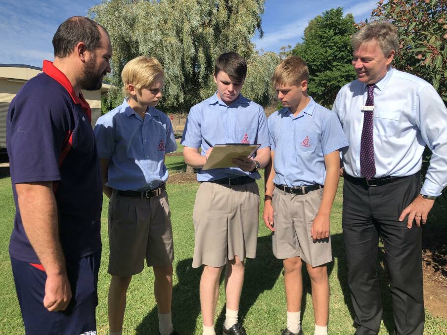 CONVERSATION: Calrossy teacher Conrad Starr with students Archie Cudmore, Sam Grant and Blair Logan and principal David Smith with the Banksia petition. 