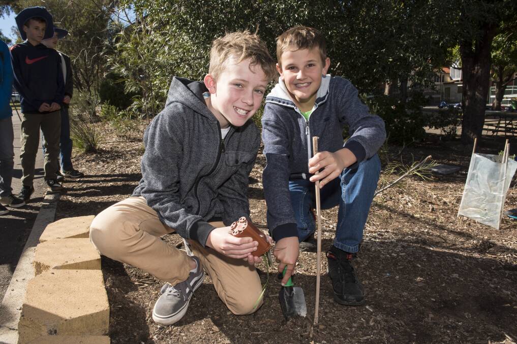 DIGGING DEEP: Hugo Pollard and Jacob McKinnon are ready to plant their trees. 210717PHC22