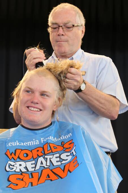PAY BACK: Teacher Peter Fowler continues to work on Jason Williams' locks as part of the fundraiser.