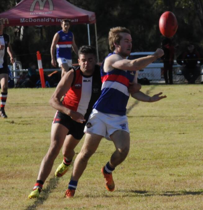 IN THE NICK OF TIME: Gunnedah Bulldogs AFC player Adam Curgenven gets his handball away under pressure from an opponent at Inverell on Saturday.