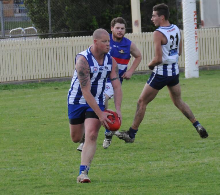KICKING OUT OF DANGER: Colin Daye looks for a Tamworth Kangaroos teammate as he prepares to drive the ball downfield during the TAFL preliminary final.