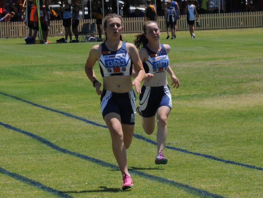LOCAL RIVALRY: Tamworth duo Laura Sadler and Bridie Martin battle out a 100m race on the first day of the annual New England Zone Championships.