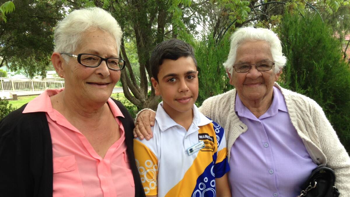 Malik and grandmothers: Malik Hunt being presented with his SRC Badge from Aunty Nean and Nan Marie.