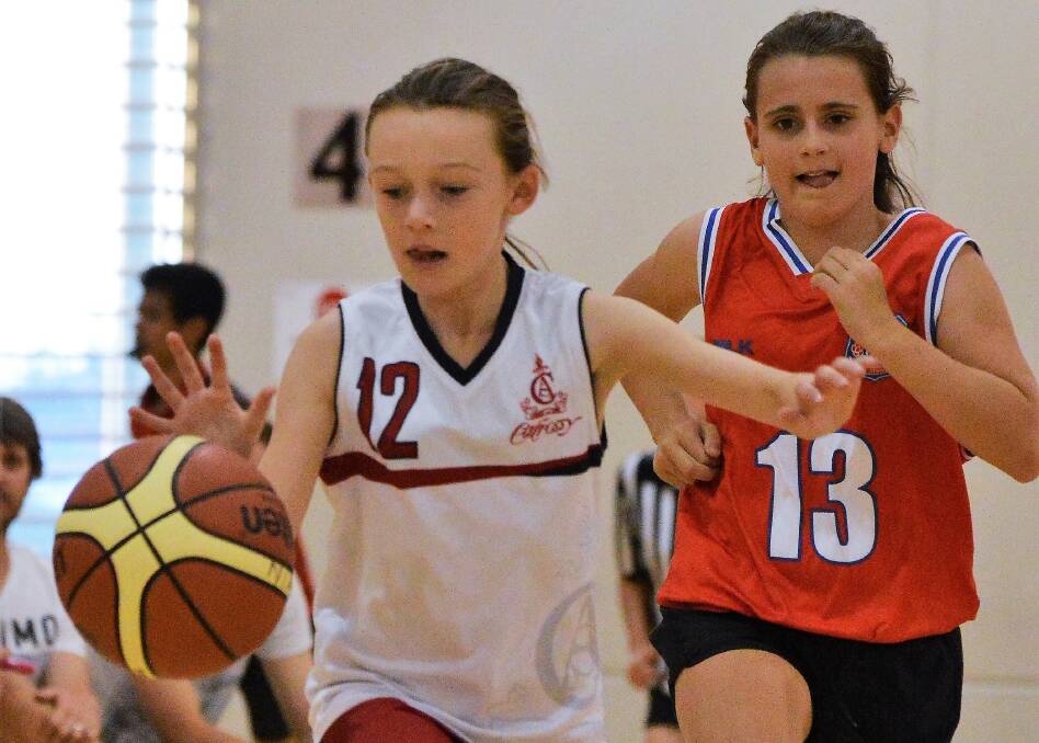 Eliza Kearney,12, drives towards the hoop with Charlotte Good in pursuit.