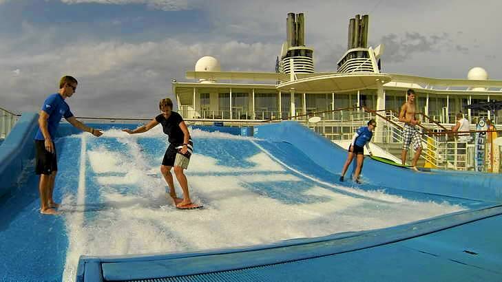 The writer tries surfing on a Flowrider on board the Oasis of the Seas.