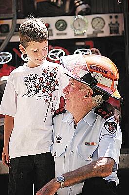 Dedication: Captain Gerry Cannon shared a proud moment with his grandson Jaygon Cannon as he was recognised for 50 years with the NSW Fire Brigade yesterday. Photo: Robert Chappel