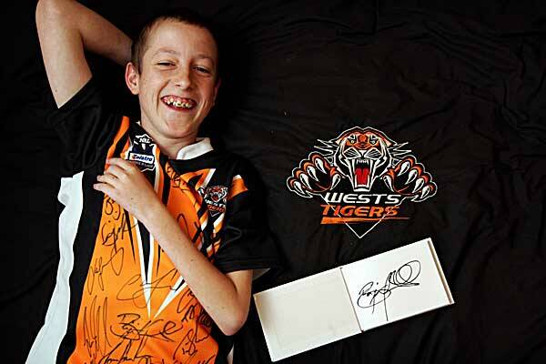 HAPPY AS: Zachary Whetton, a huge West Tigers fan, with his Benji Marshall autograph and Tigers gear at home.  Photo: Kitty Hill 090712KHB08