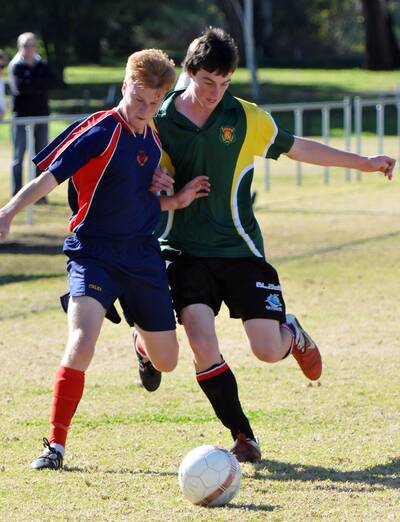 Oxley�s Dylan May and Gunnedah High's Matt Hassan shoulder each other for the ball during yesterday�s regional knockout final. 130612GOC03