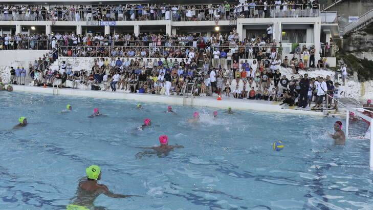 A crowd watches the Australian Olympic Water Polo (yellow caps) team play International All Stars team in an exhibition match at the Bondi Icebergs pool in Sydney.