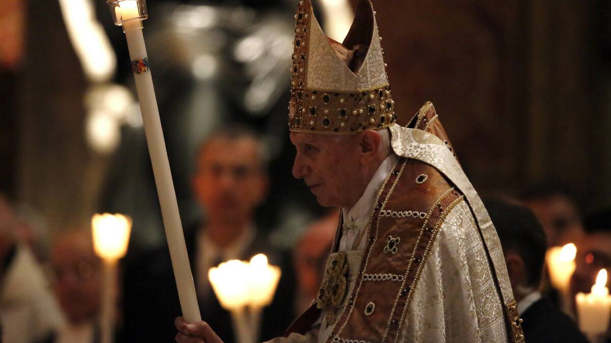 Pope Benedict XVI holds a candle as he arrive to leads a mass in the Vatican February 2, 2013.  Photo: REUTERS