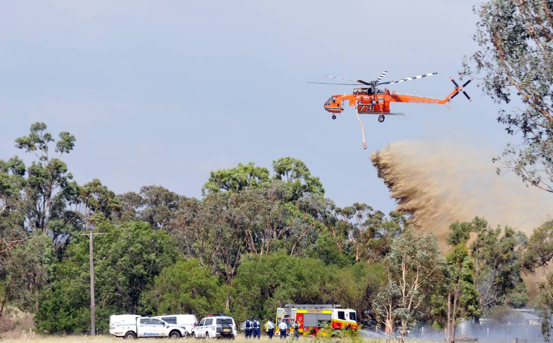 AIR RECRUIT: The Gypsy Lady sky-crane, pictured here in action at a blaze at Impala Estate on Friday, could return to base in Sydney as early as today. Photo: Geoff O’Neill 030114GOI01