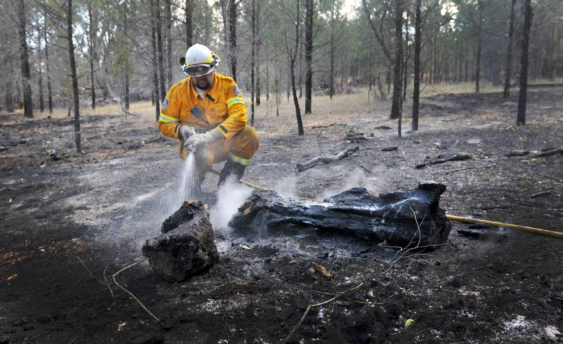 BLACKING OUT: RFS volunteers spent much of the day trying to douse hotspots after a firebug sparked a blaze near Moore Creek. Photo: Gareth Gardner  080114GGG06