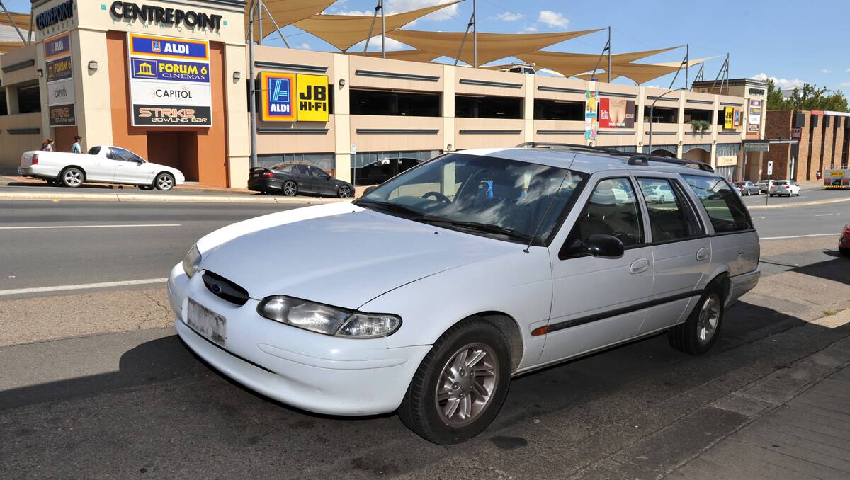TOWED: A Ford Falcon station wagon abandoned in a car park space on Brisbane St for almost three weeks was finally removed by the council last Tuesday night.  Photo: Barry Smith 310113BSD02