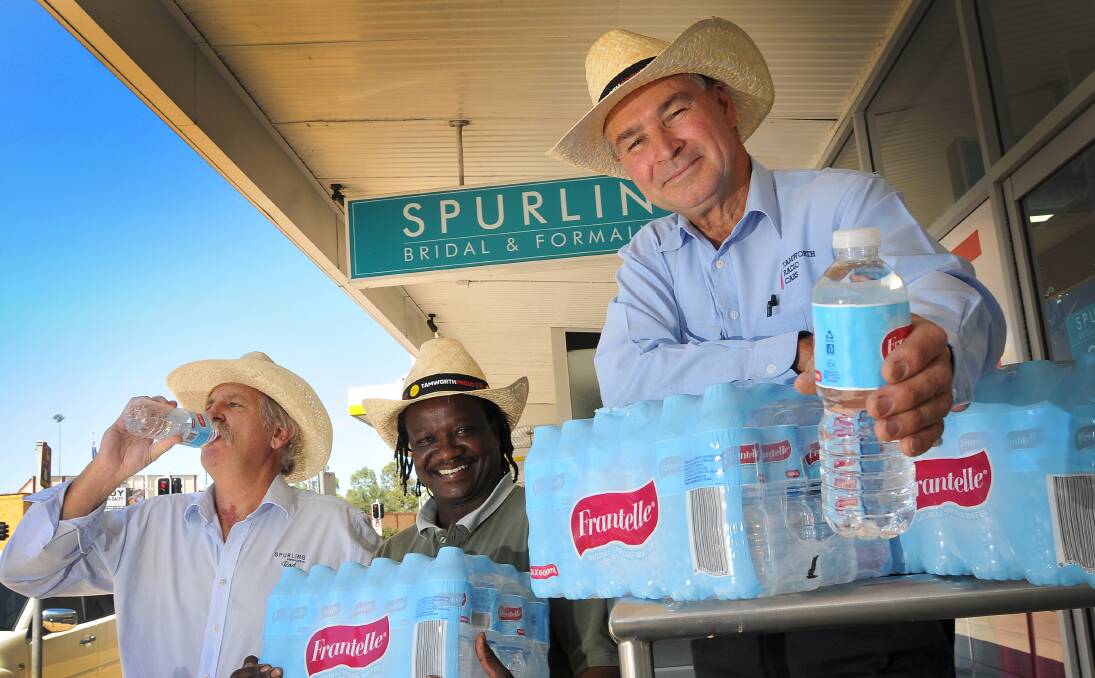 CHEERS: Rod Hands, of Spurling Bridal and Formal Wear, the Safari Club’s Elliott Dube and Tamworth Taxis director Greg Rowland check out the bottles of water that will be handed out free to passengers during the country music festival. Photo: Gareth Gardner  130114GGC01