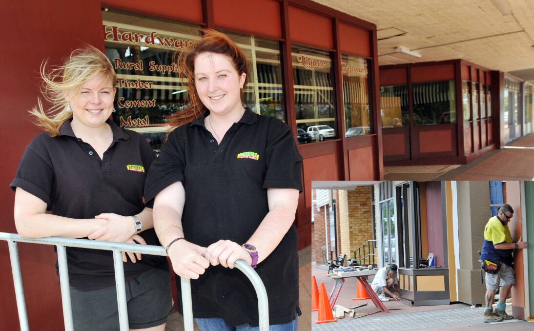 STARK CONTRAST: Tori Constable and Nicole Marr outside the new-look Friendly Grocer. Photos: Geoff O’Neill 051213GOD13 INSET - TRANSFORMATION: Set workers construct makeshift facades along Single St in preparation for filming. 051213GOD01