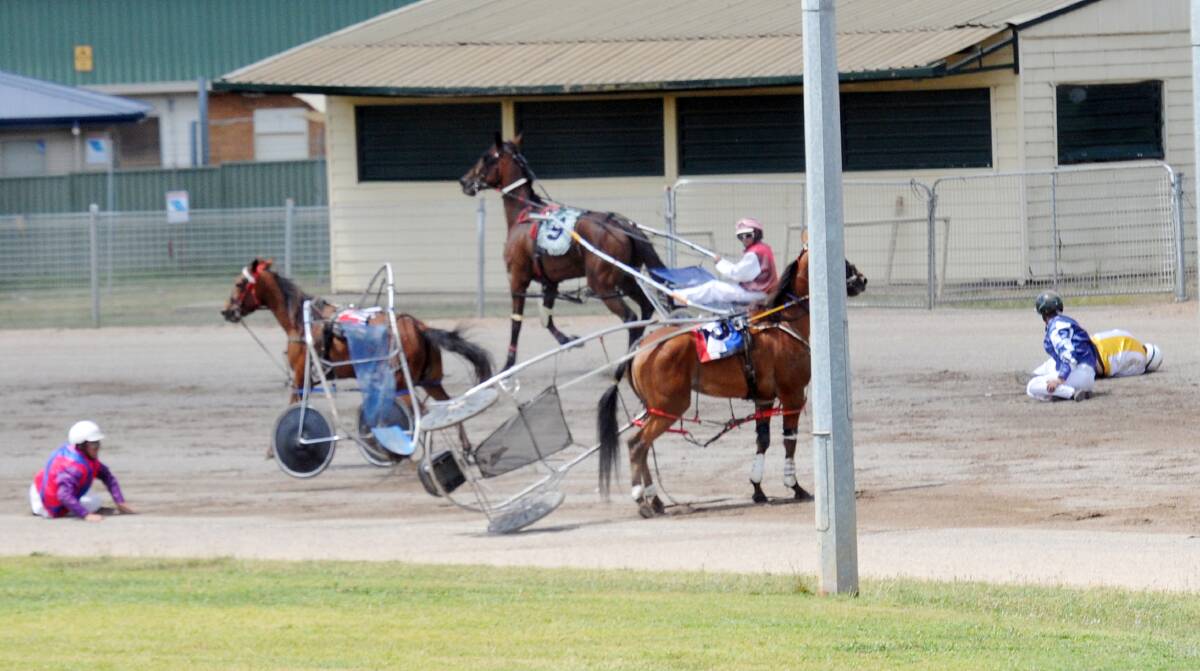 The aftermath of a terrible race three crash at the Tamworth Harness Club meeting yesterday. Photo: Geoff O’Neill 271213GOD02