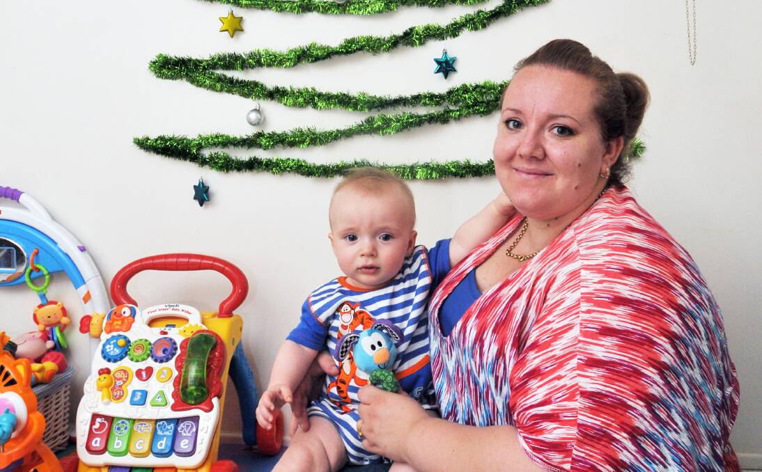 INNOVATIVE: Oxley Vale mum Kayarna Pepper and her seven-month-old son, Logan, take a break under their wall-mounted tree. Photo: Geoff O’Neill 121213GOE01