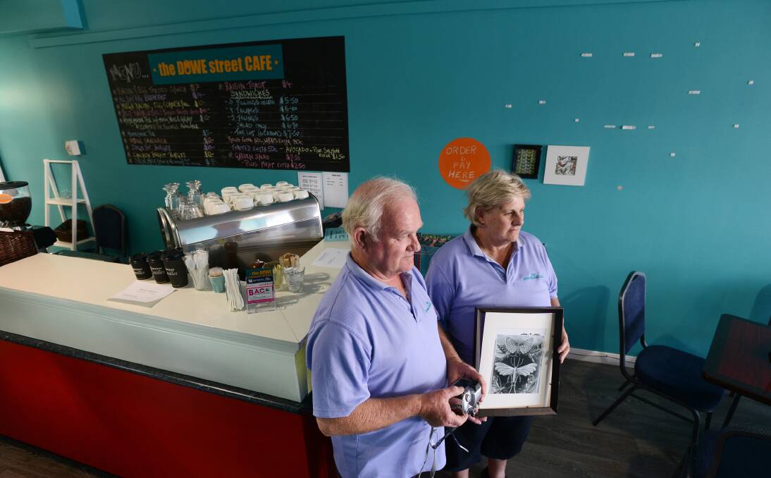 ALMIGHTY MESS: Dowe Street Cafe owners, Bob and Vanessa Seeley, have only just finished picking up the pieces, and   now have to restore the wall hangings after their shop was targeted  over the weekend. Photo: Barry Smith 130114BSD01