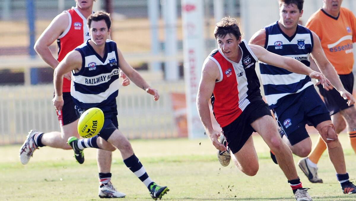 New Inverell Saint Hayden Chappell has eyes for the ball against  Muswellbrook Cats pair Nick Bottrill (left) and Brian Martin (back right) .  Photo: Geoff O’Neill 130413GOG02