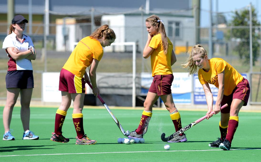 Alice Arnott takes a shot on goal during a scoring drill at last Sunday's NIAS session while assistant coach Kim Kelly (left) looks on. Emily Chaffey (second from left) is about to go while Tahlia Rekunow (second from right) moves back into line. Photo: Barry Smith 151213BSB06