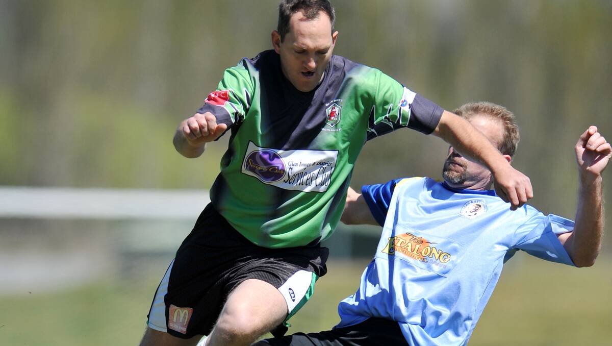 Glen Innes Highlanders’ Daniel Ferris is tackled by RC United’s Dave Brett (RC) during  Saturday group stages at the over 35s tournament in Armidale. RC Utd went on to claim the major prize. 131012GRA32