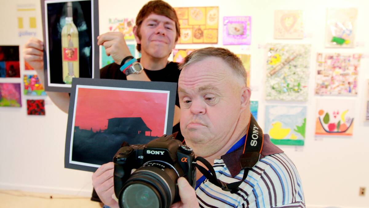 aHAPPY SNAPPERS: Local artists Kyle Redding, left, with his Kyle in a Bottle work and Guy Derrick with his art work titled Sunrise Shed and his other favourite thing, his Sony digital camera. Photo: Robert Chappel 131112RCB02
