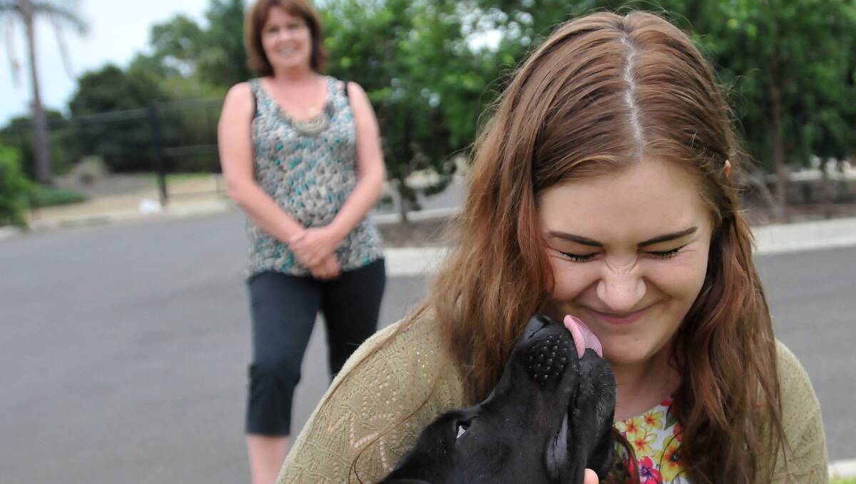 PUPPY LOVE: Ned the rescue dog will be rehomed through a new animal organisation in Tamworth founded by Tamworth woman Kate Davies, left, that employs foster carers such as Ellymay Sheedy. Photo: Geoff O’Neill 220313GOE01