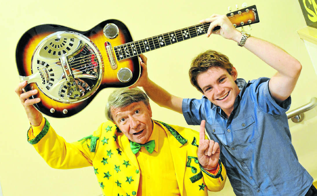 MUSICAL MOMENT: Morning Variety Show host Jim Haynes with talented young muso Liam Kennedy-Clark, who was surprised with the gift of a brand new guitar. Photo: Barry Smith 220114BSH03
