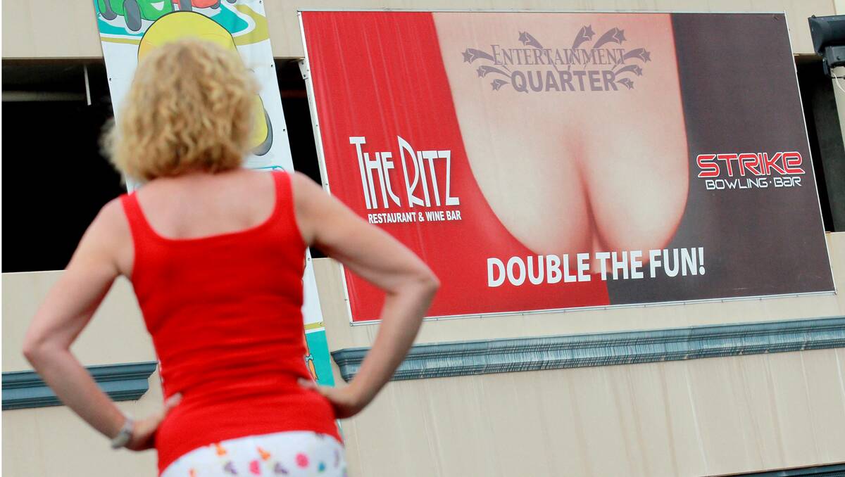HARMLESS FUN? A busty Brisbane St billboard is causing quite a debate among businesses and residents. Photo: Robert Chappel 281212RCH04