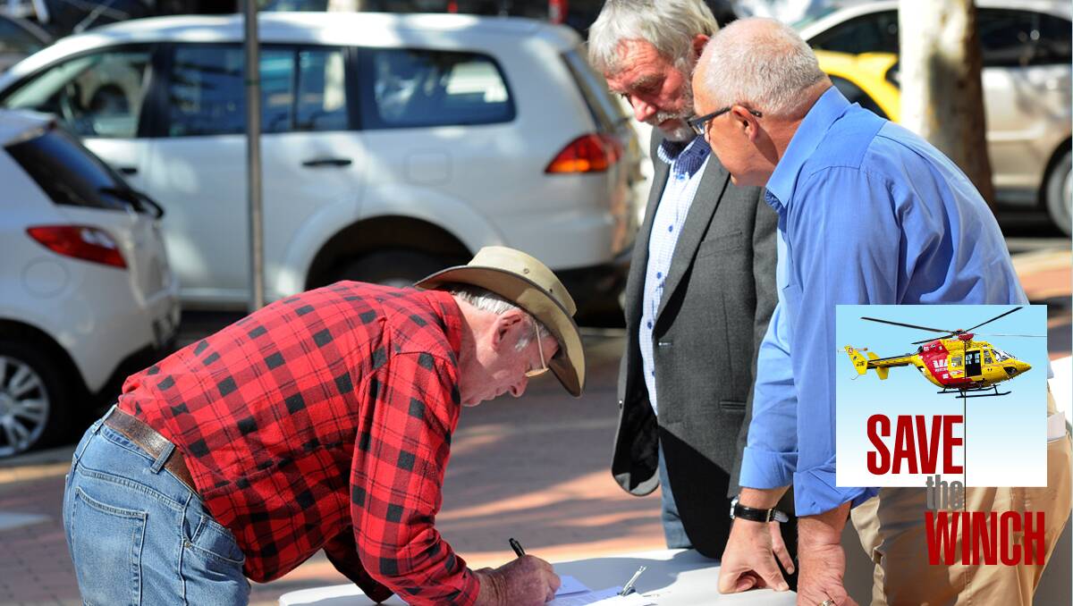 SIGN UP: Kevin Baker signs the petition to save the winch yesterday as Russell Webb and Tim Coates look on. Photo: Gareth Gardner 160813GGC02