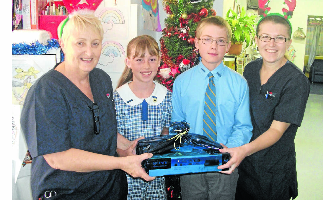 CARING KIND: Nundle Public School captains Catrin Evans (second from left) and Samuel Hoad (third from left) present a Blue-Ray player and gift card to paediatric nursing unit manager Terese Madden (left) and children’s ward nurse Sandra Sutcliffe.