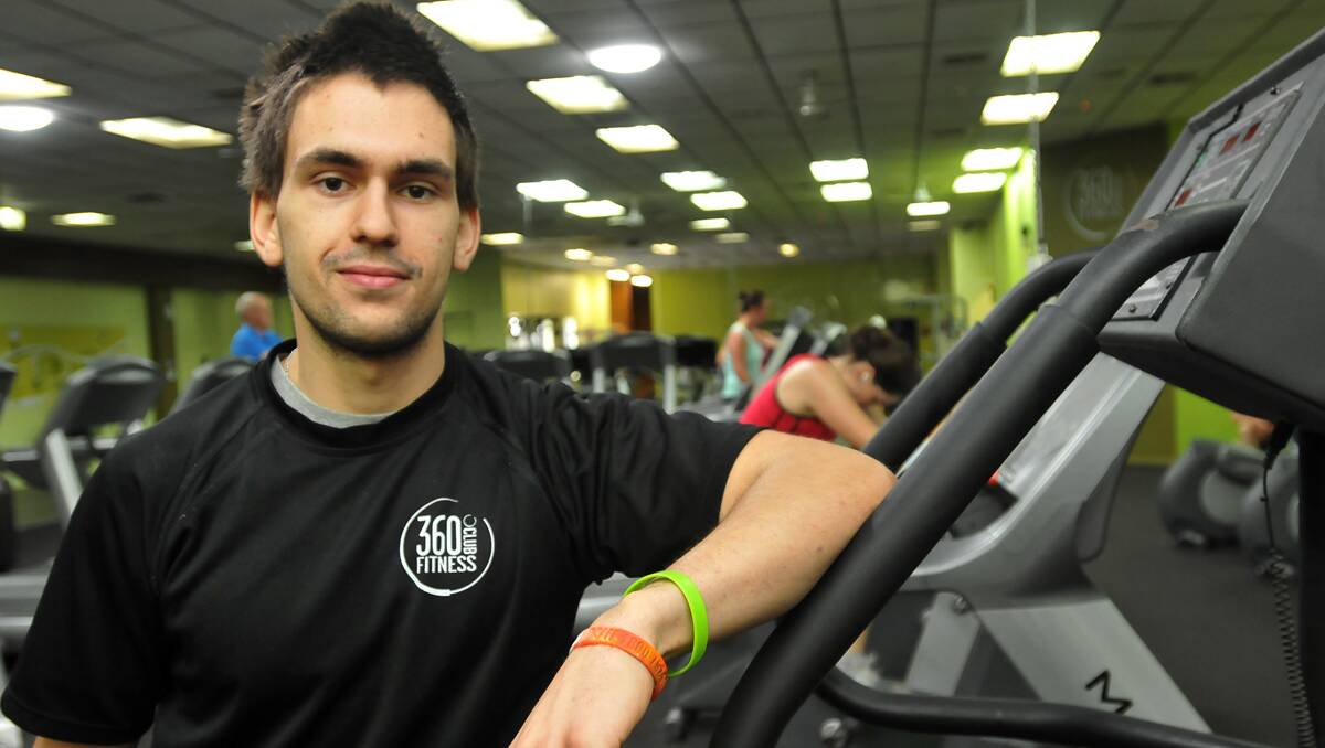 job to do: Personal trainer Eli Latsinos works his way around a busy gym helping people drop the festive flab. 271212GOA03