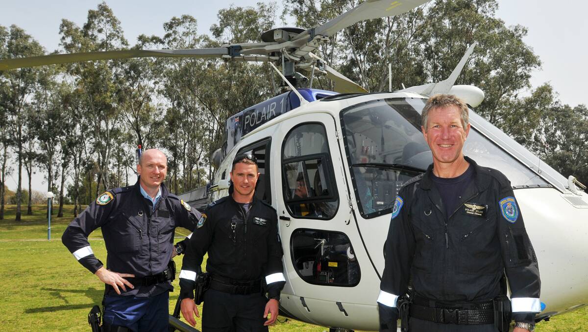 SAFE LANDING: Senior constables David Hollier, left, and Chris Tegart and Special Constable Graeme Gleeson were aboard PolAir when it took a pit stop in the centre of Tamworth yesterday. Photo: Geoff O’Neill 240913GOB04