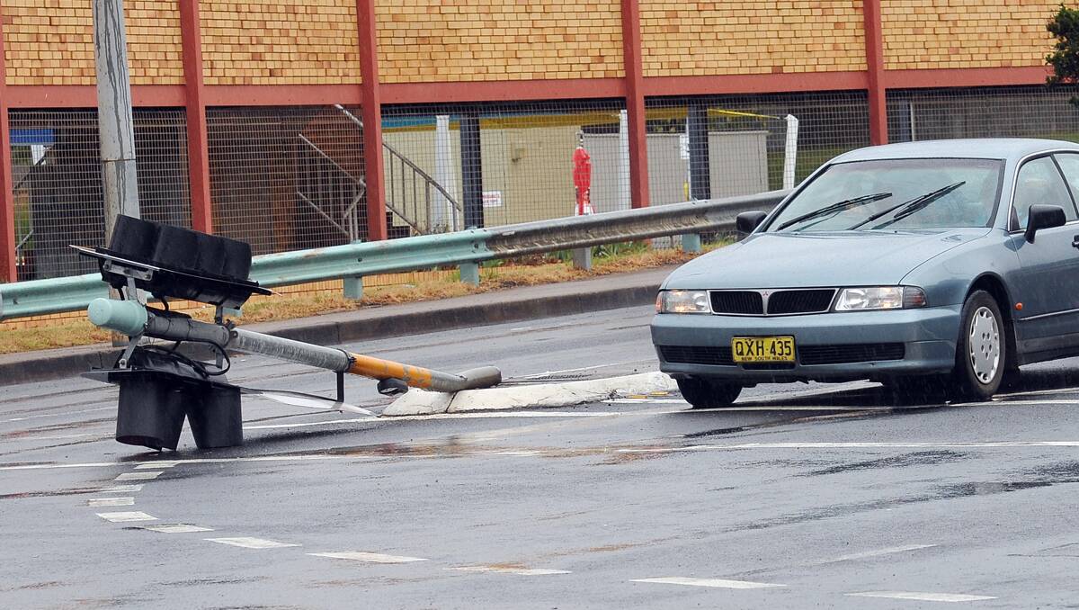 OOPS: A traffic light at the intersection of Bridge St and Kable Ave was knocked over by a motorist yesterday in the wet weather.  Photo: Geoff O’Neill 280113GOE02