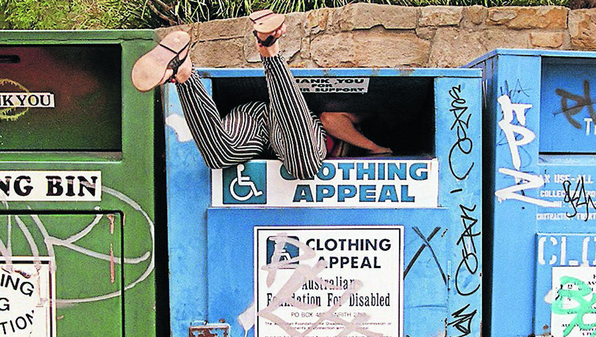 BUSTED: This woman was caught in the act of stealing from a clothing bin in Sydney, but it’s not unique to metropolitan areas. Photo: George Fetting, Fairfax