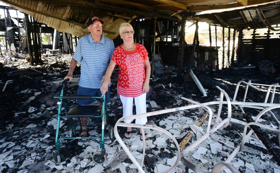 LIFE IN RUINS: Bingara housefire victim Ron Surrage with his sister, Carolyn Taylor, in the ruins of the Finch St home. Despite losing his home, they credit a smoke alarm with saving Mr Surrage’s life. Photo: Barry Smith 171213BSA11