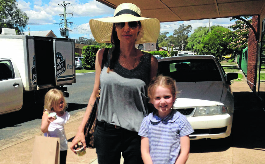 BRUSH WITH FAME: Angelina Jolie with Werris Creek girl Laura Davis in Single St yesterday afternoon. Ms Jolie’s daughter, Vivienne Jolie-Pitt, stands patiently to one side while Laura’s mum, Jess Davis, takes the snap.