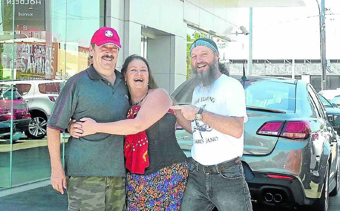 THANKS A BUNCH: Kensell Holden salesman Rene Bonomo was on the receiving end of a big hug of gratitude from Donna Reynolds and Ron DImmick from The Leaping Lizards after their vehicle packed it in right at the start of the festival. Photo: Anna Rose