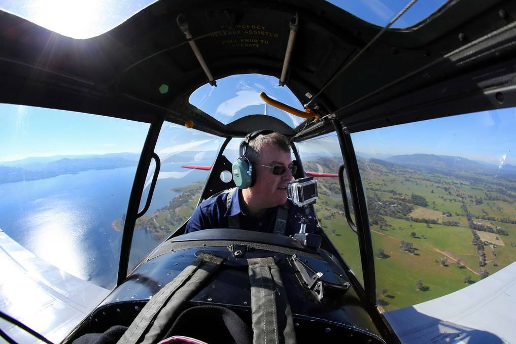 Pilot Stephen Death at the controls of a De Havilland Chipmunk aeroplane over Albury and Lake Hume. Picture: Matthew Smithwick