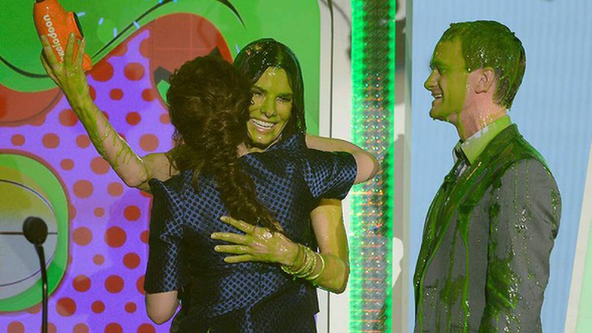 Sandra Bullock embraces Kristen Stewart while Neil Patrick Harris watches on during Nickelodeon's 26th Annual Kids' Choice Awards. Photo: Getty Images
