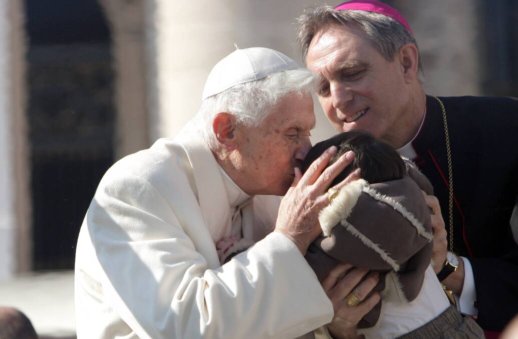 Pope Benedict XVI kisses a child lifted up by the Pontiff's personal secretary Georg Ganswein, as he leaves St. Peter's Square at the end of his final general audience in Vatican City. Photo by Franco Origlia/Getty Images