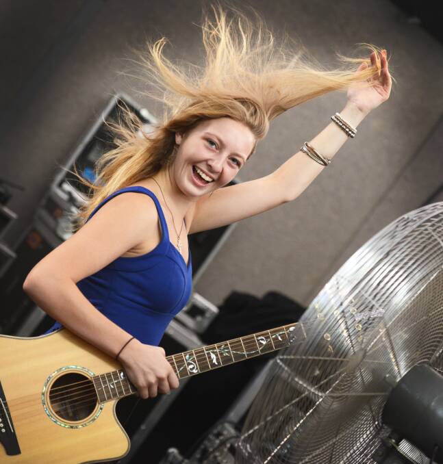 Sami Cook, 17, from Young cooling off with a fan before her gig. Photo:Barry Smith 210113BSI06