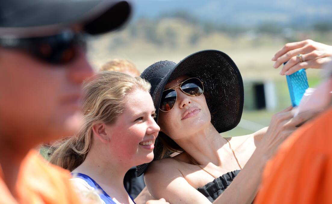 Angelina Jolie poses with fans during a visit to Werris Creek in October. Photo:Gareth Gardner. 011013GGA22