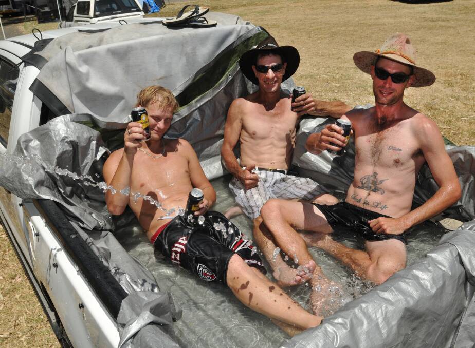 Blayne Jackson, Jeff Hardwick and Shane Rowland of Newcastle escape the heat with a pool in the back of their Hilux. Photo:Geoff O'Neill 160114GOB06