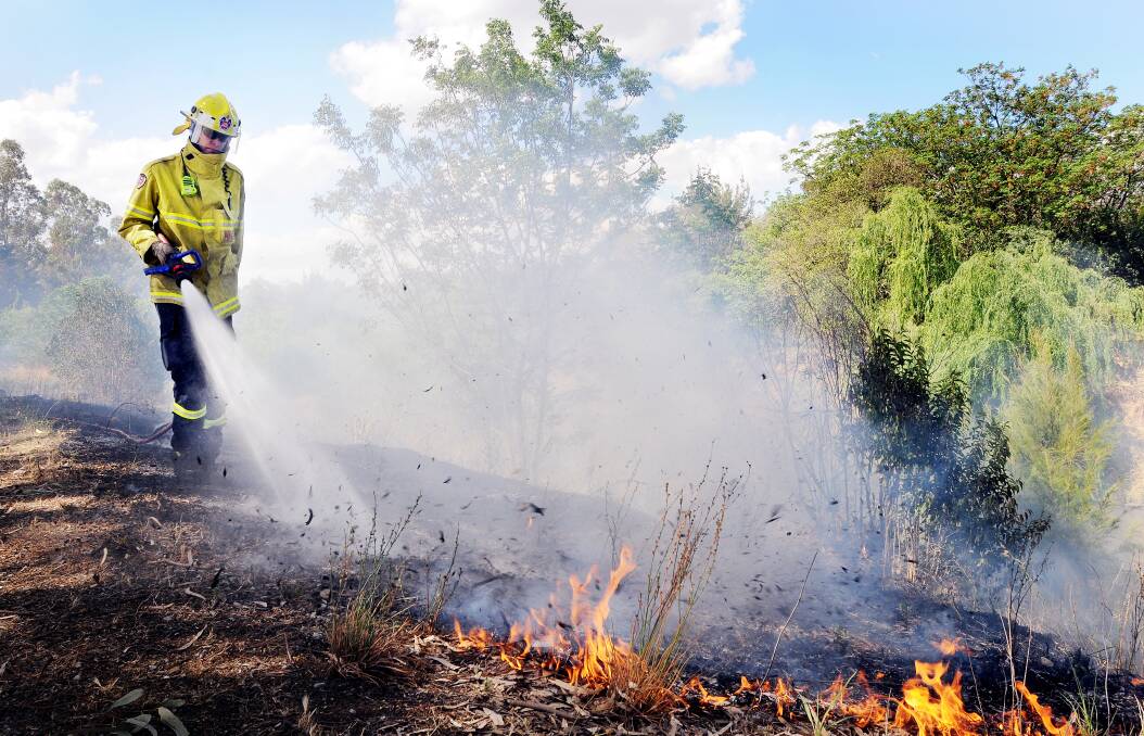Firefighters work to put out a blaze by the Peel River in October. Photo:Gareth Gardner. 30101013GGB03