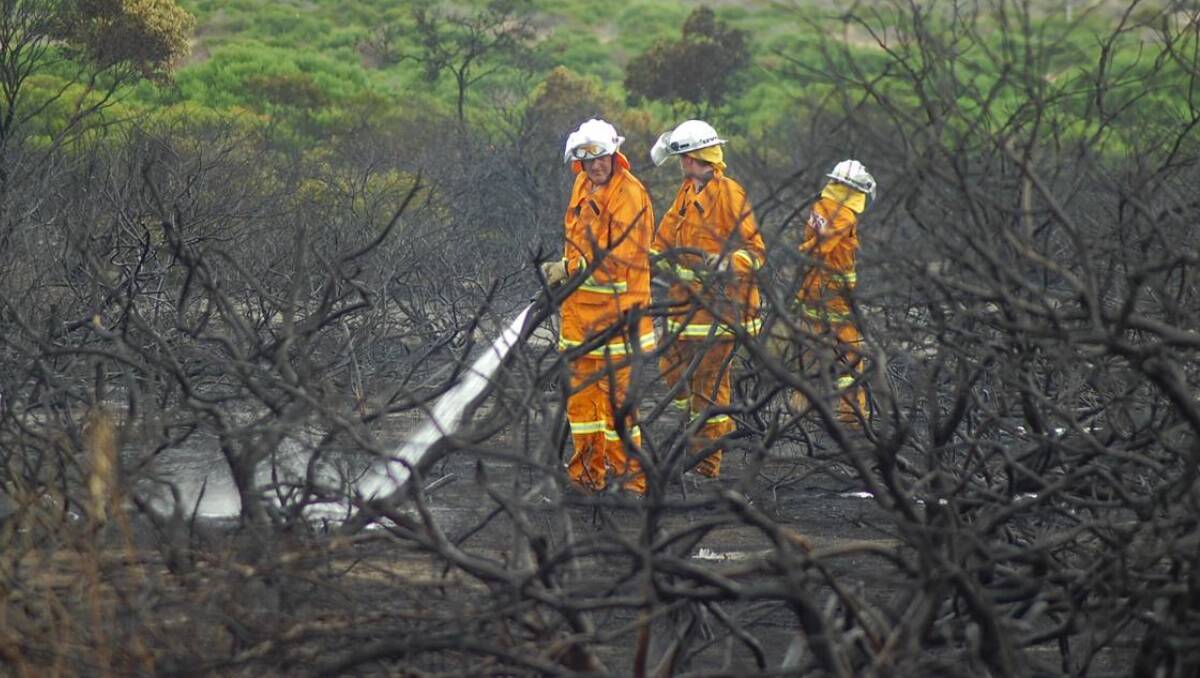 Country Fire Service volunteers put out hot spots at Point Boston fires, South Australia.